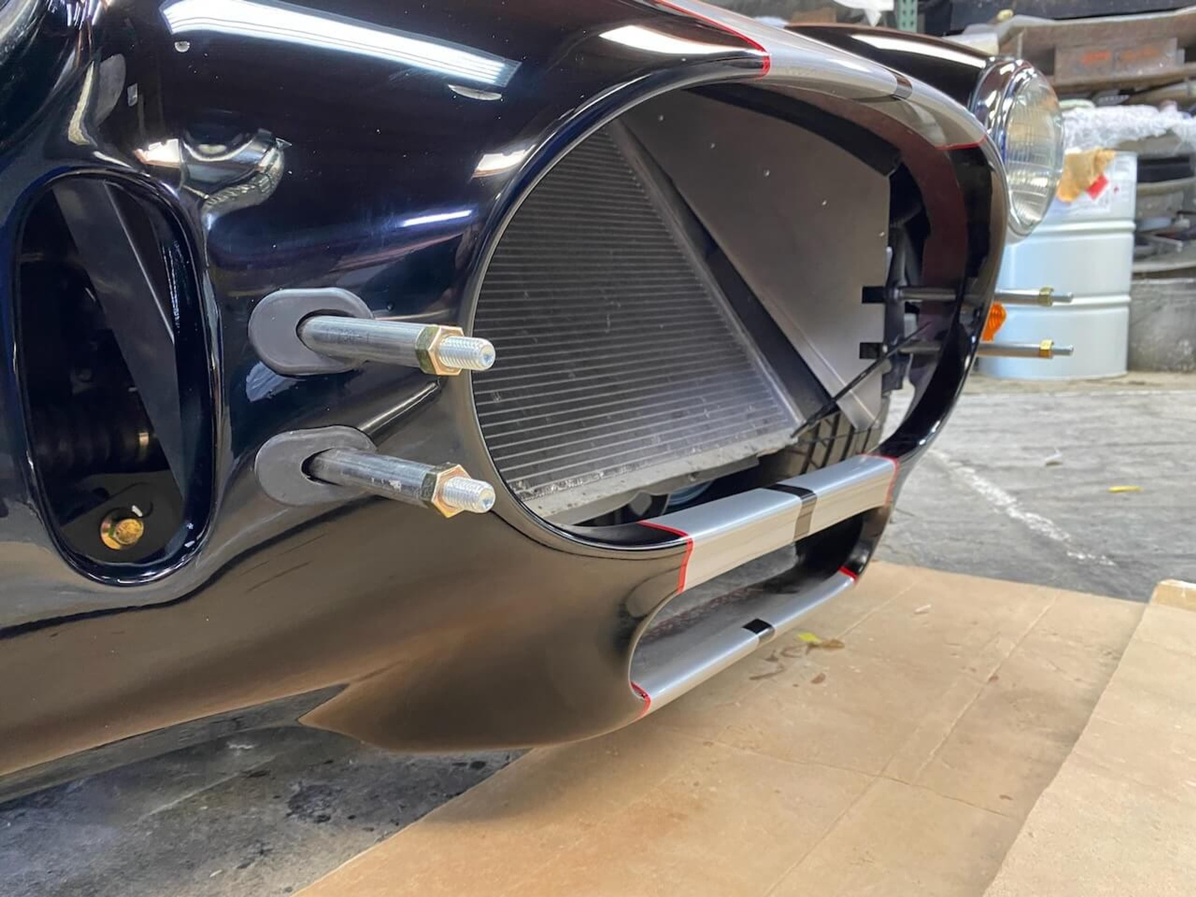 Close-up of the restored lower front opening on a Shelby Cobra-style roadster after fiberglass repair