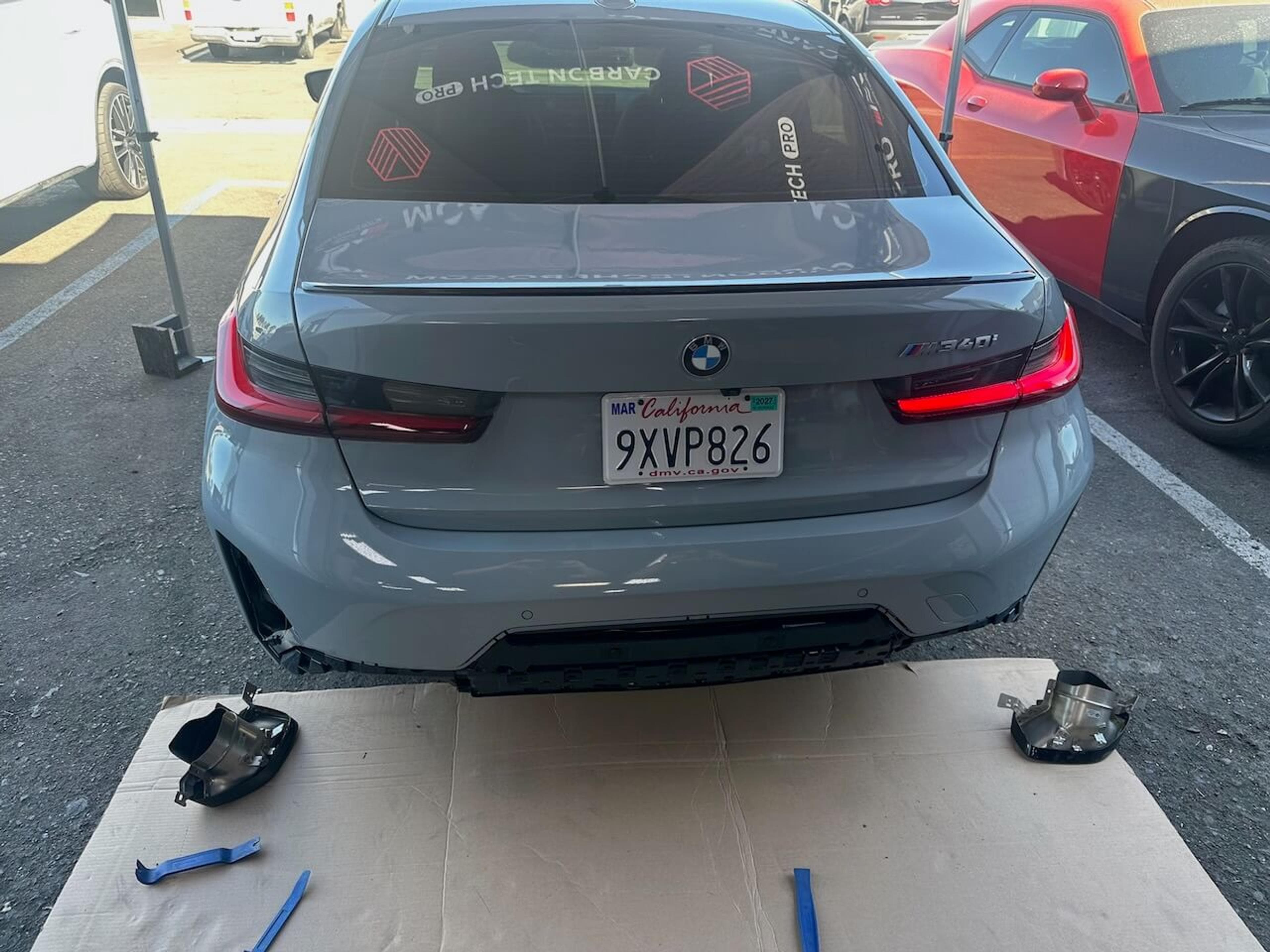 Close-up of the installed carbon fiber rear diffuser on a gray BMW M340i