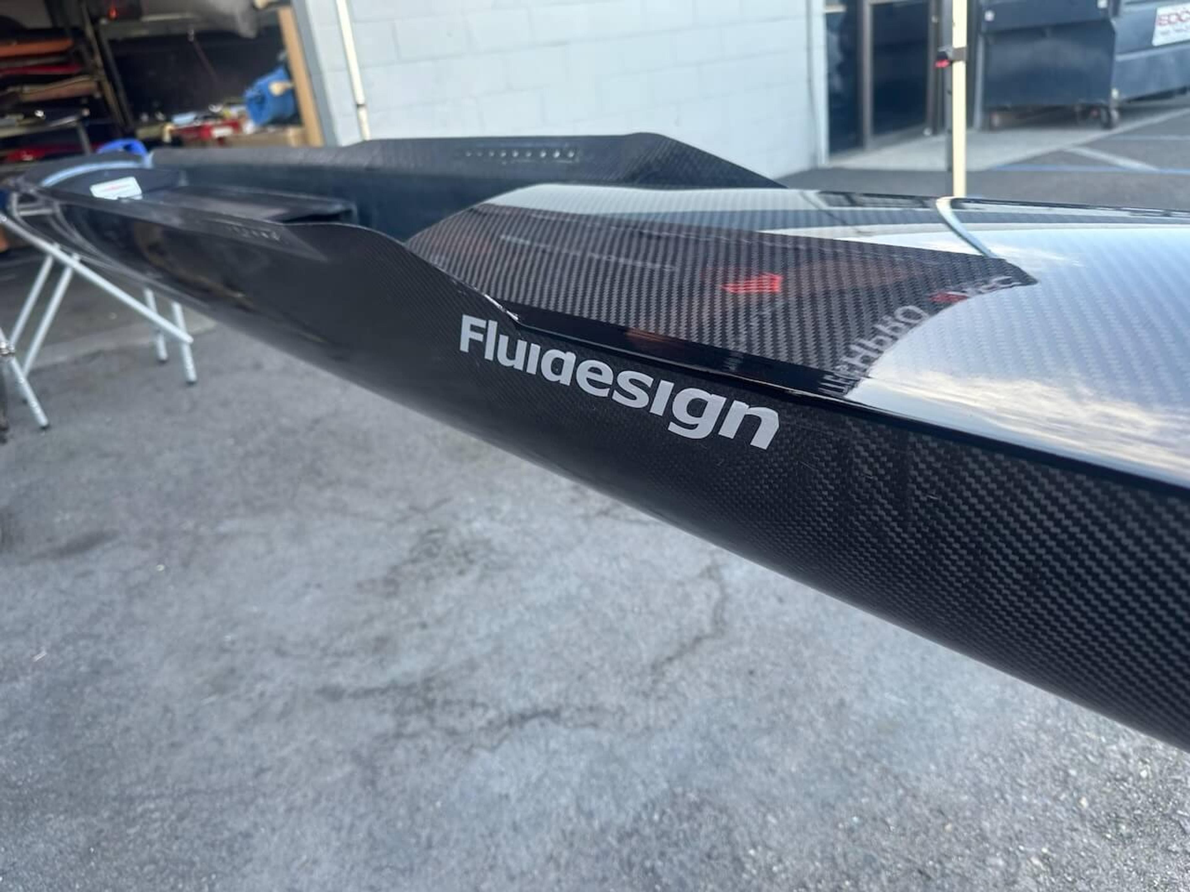 Close-up of Fluidesign logo and finished carbon fiber surface after repair