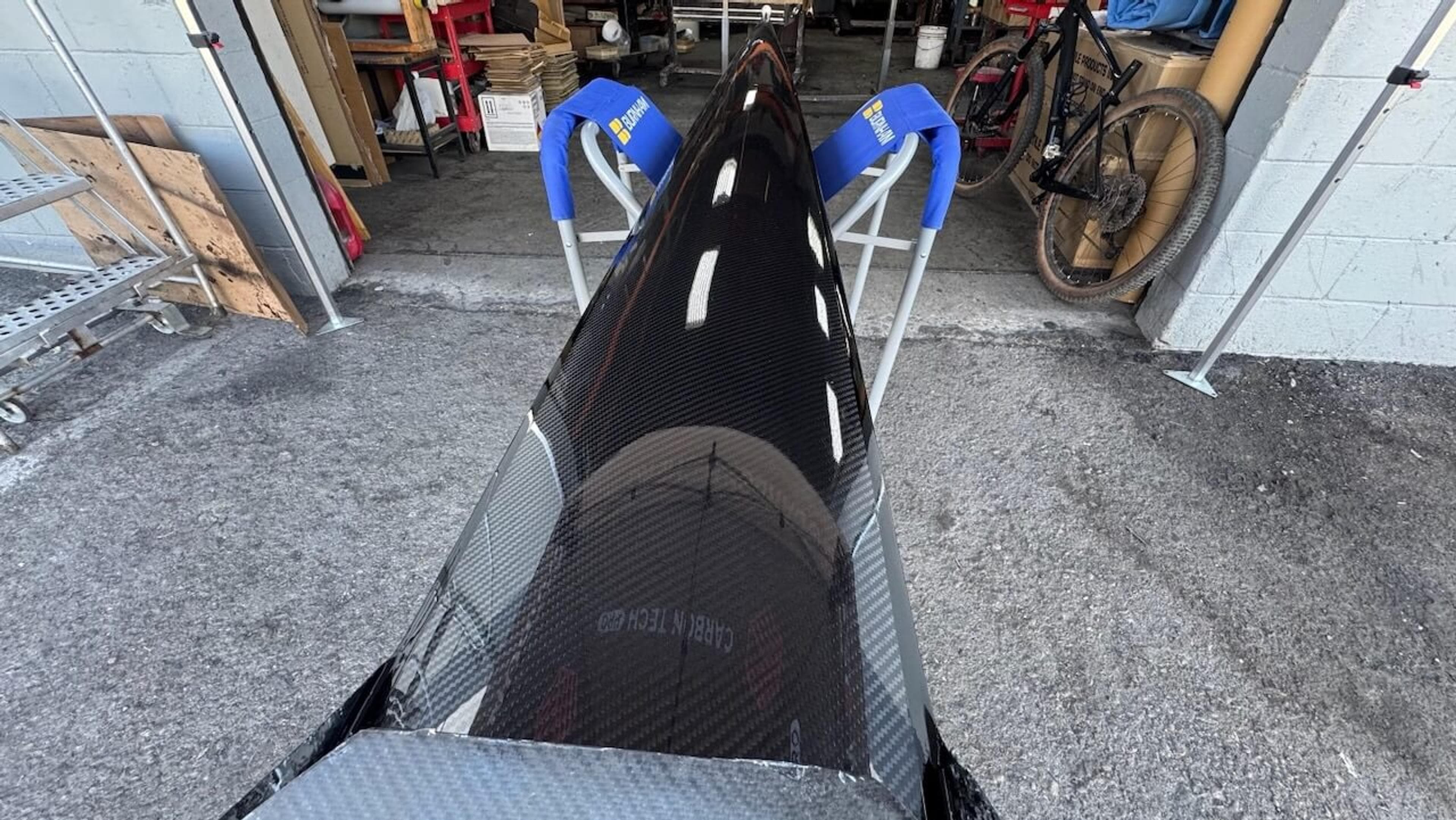 Glossy exterior of a repaired Fluidesign carbon fiber rowing shell