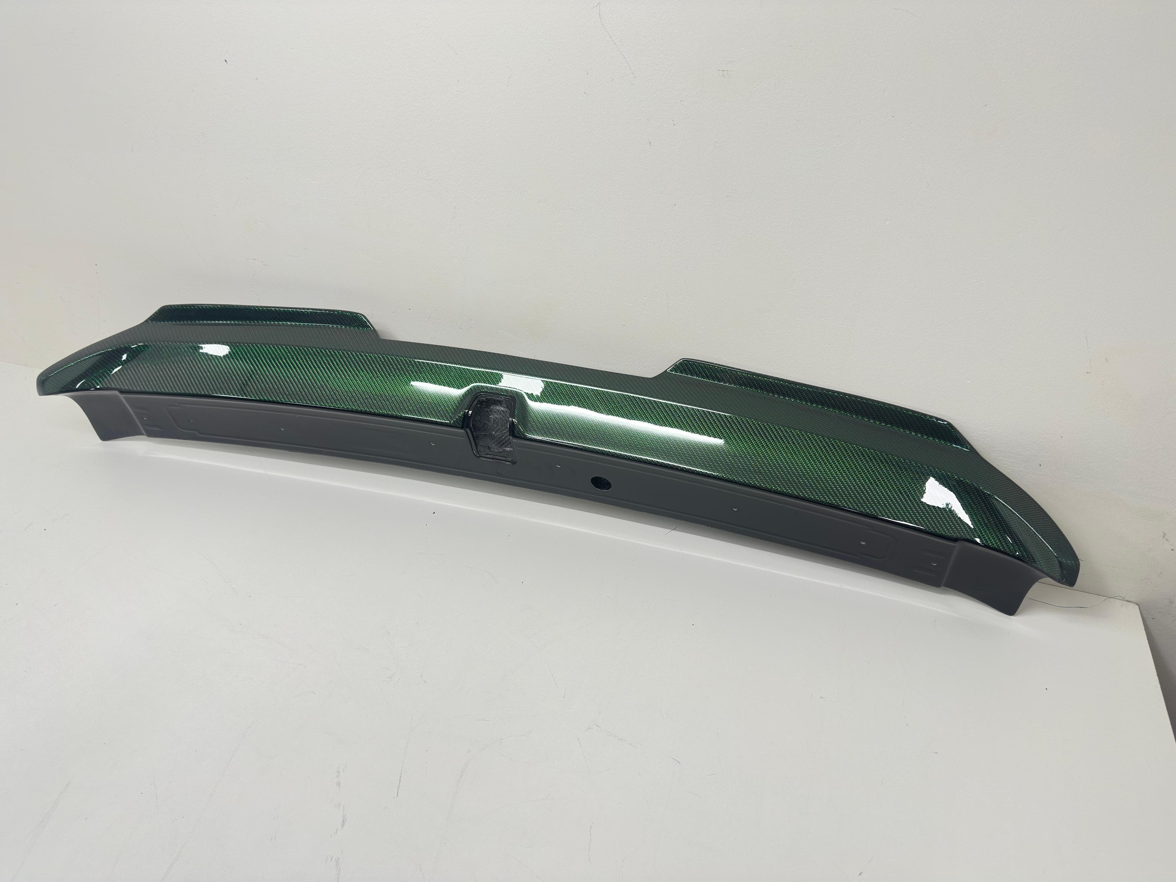 Underside mounting view of 2016-2023 Dodge Challenger green carbon fiber spoiler.