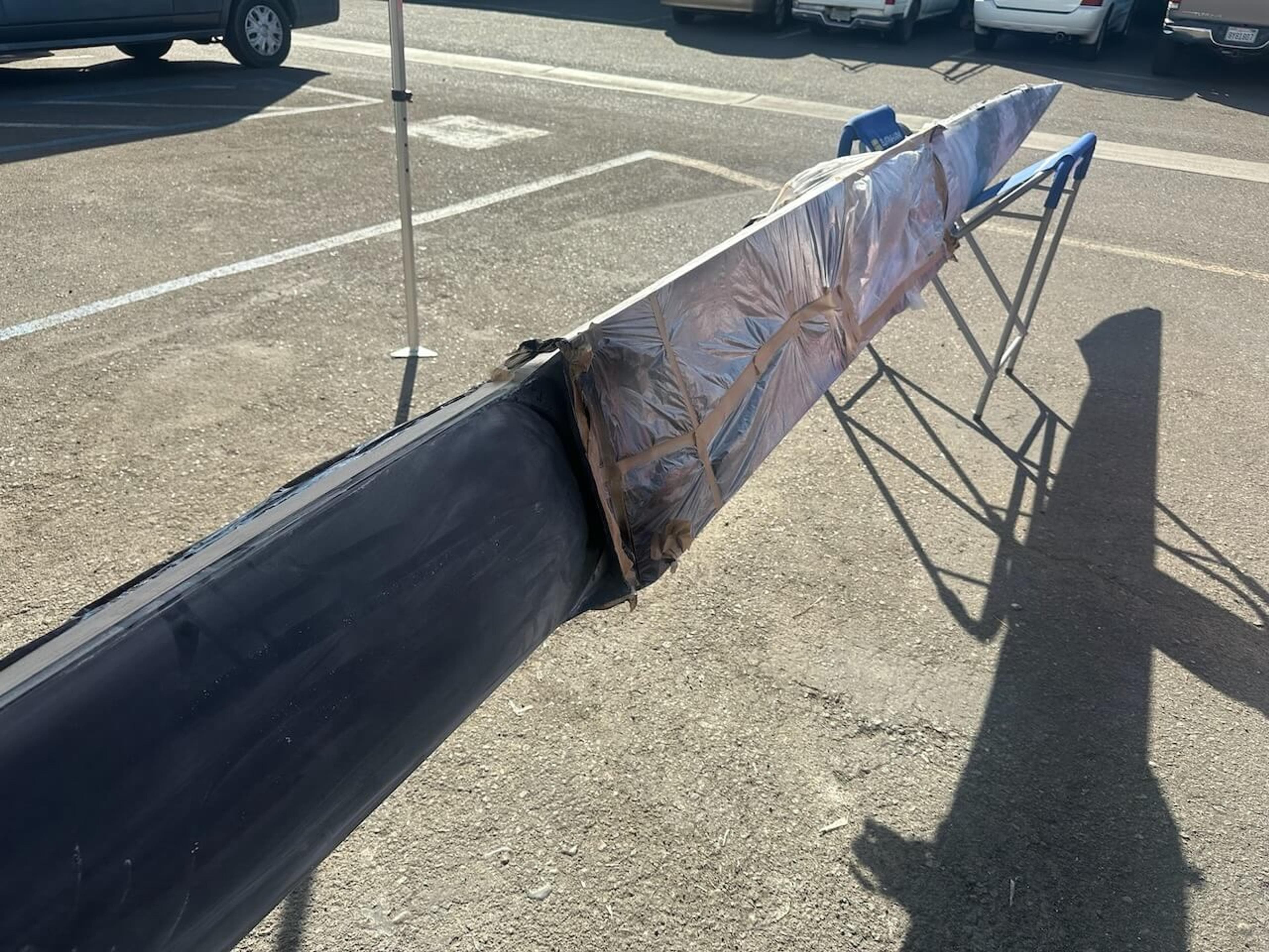 Fluidesign carbon fiber rowing shell with the repair area masked and wrapped during the repair process