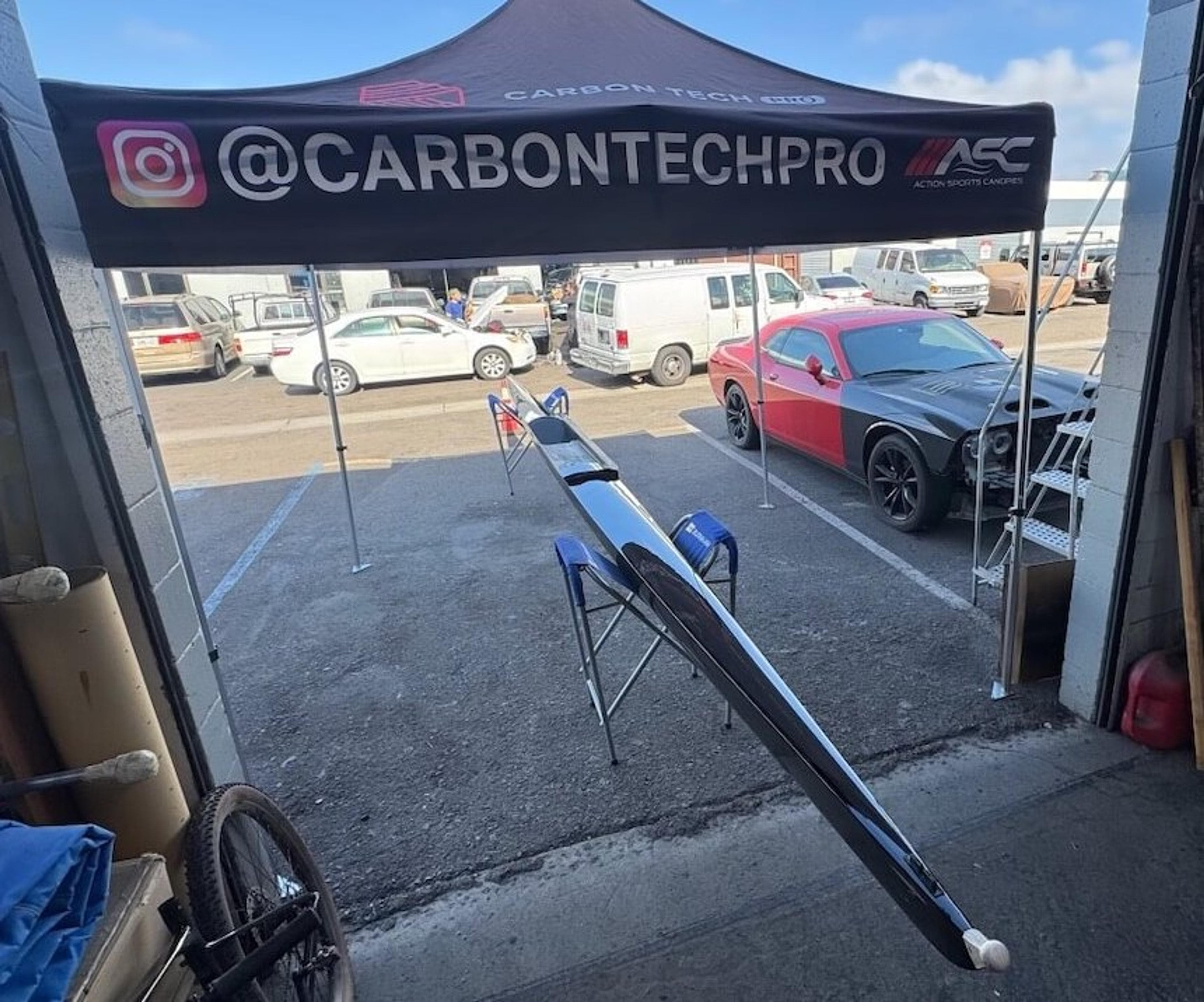 Full view of a Fluidesign carbon fiber rowing shell outside the Carbon Tech Pro shop