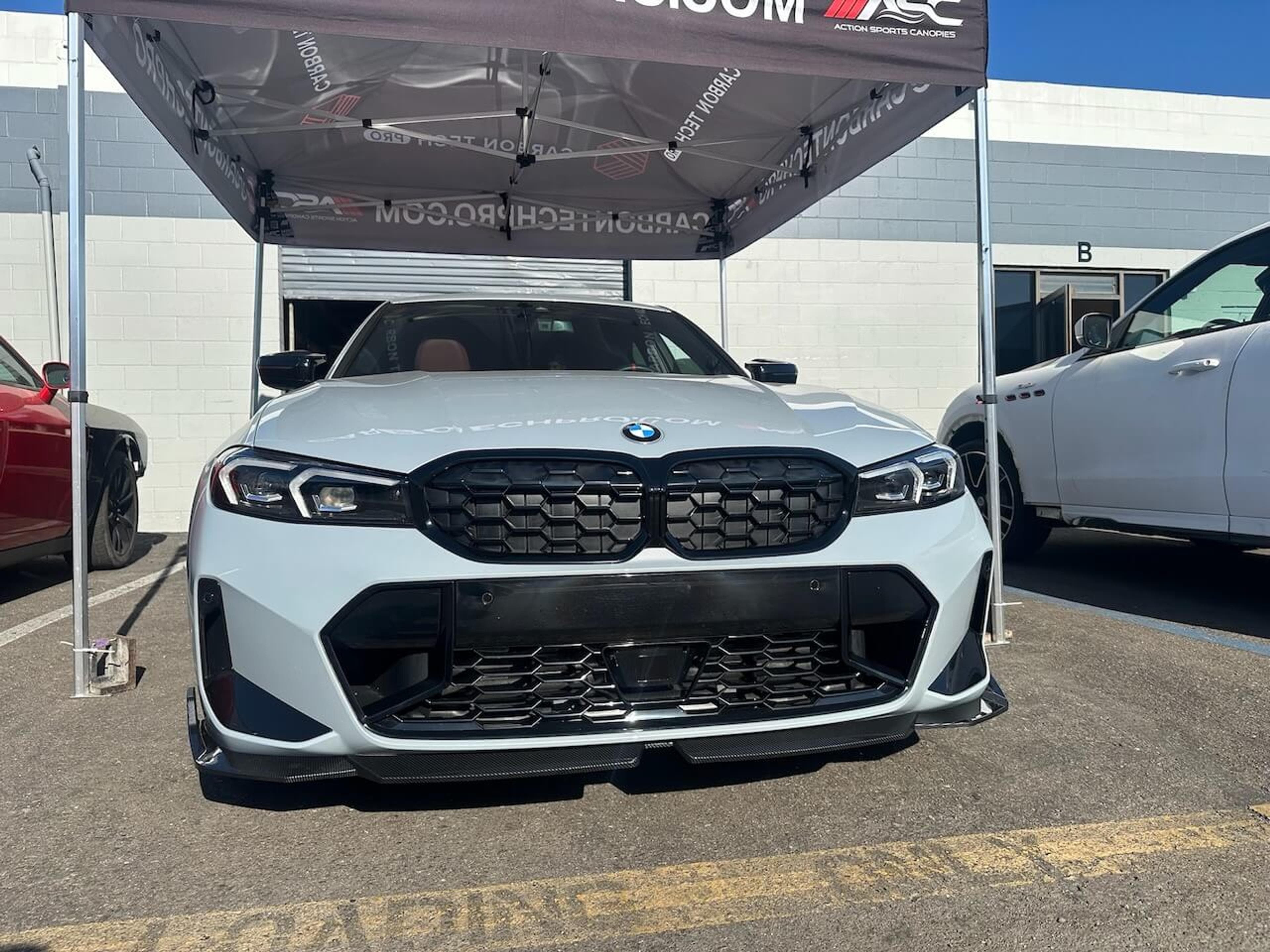 Front view of a 2026 BMW M340i with an installed carbon fiber front lip
