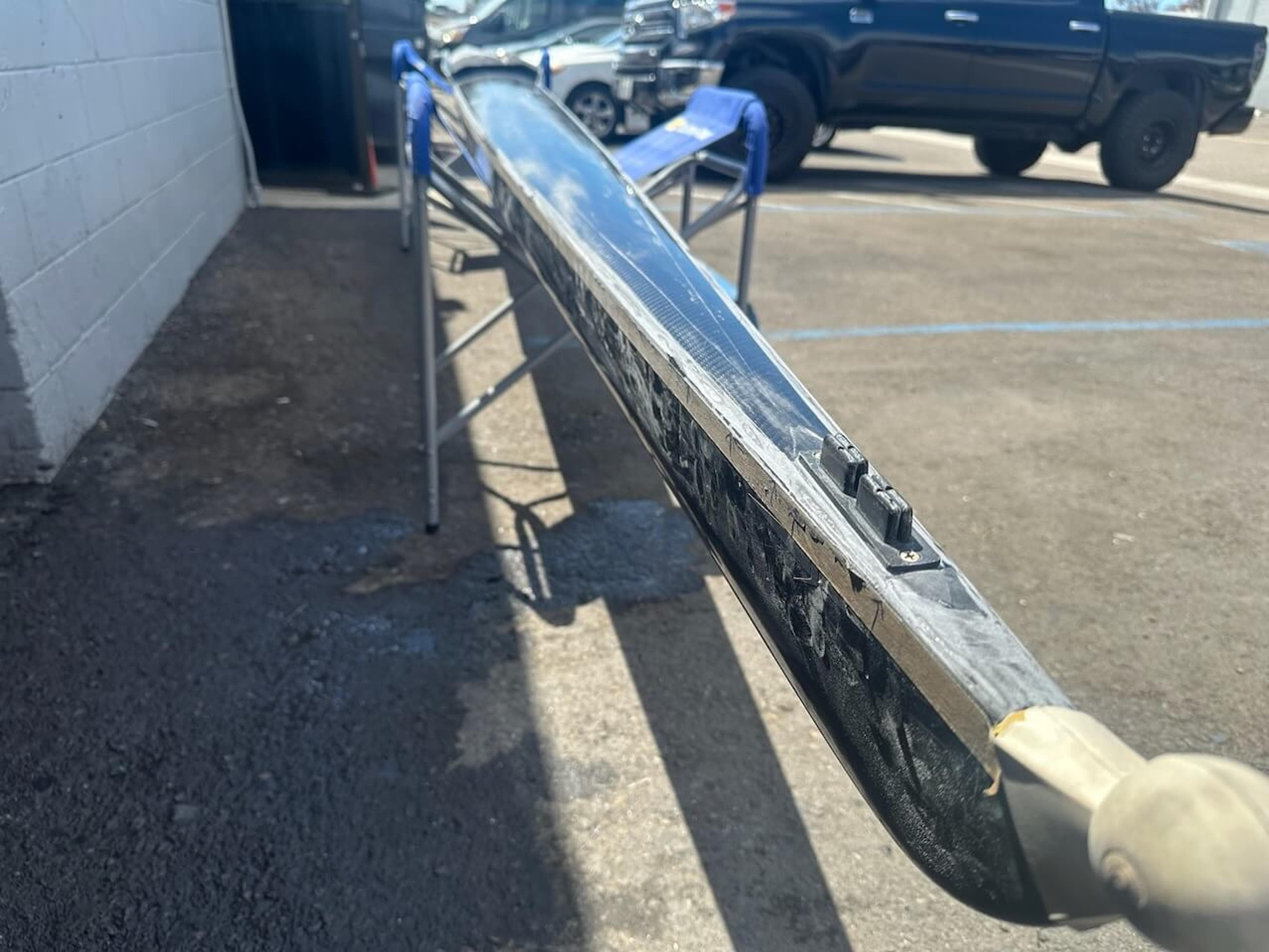 Close-up of damage along the edge of a Fluidesign carbon fiber rowing shell