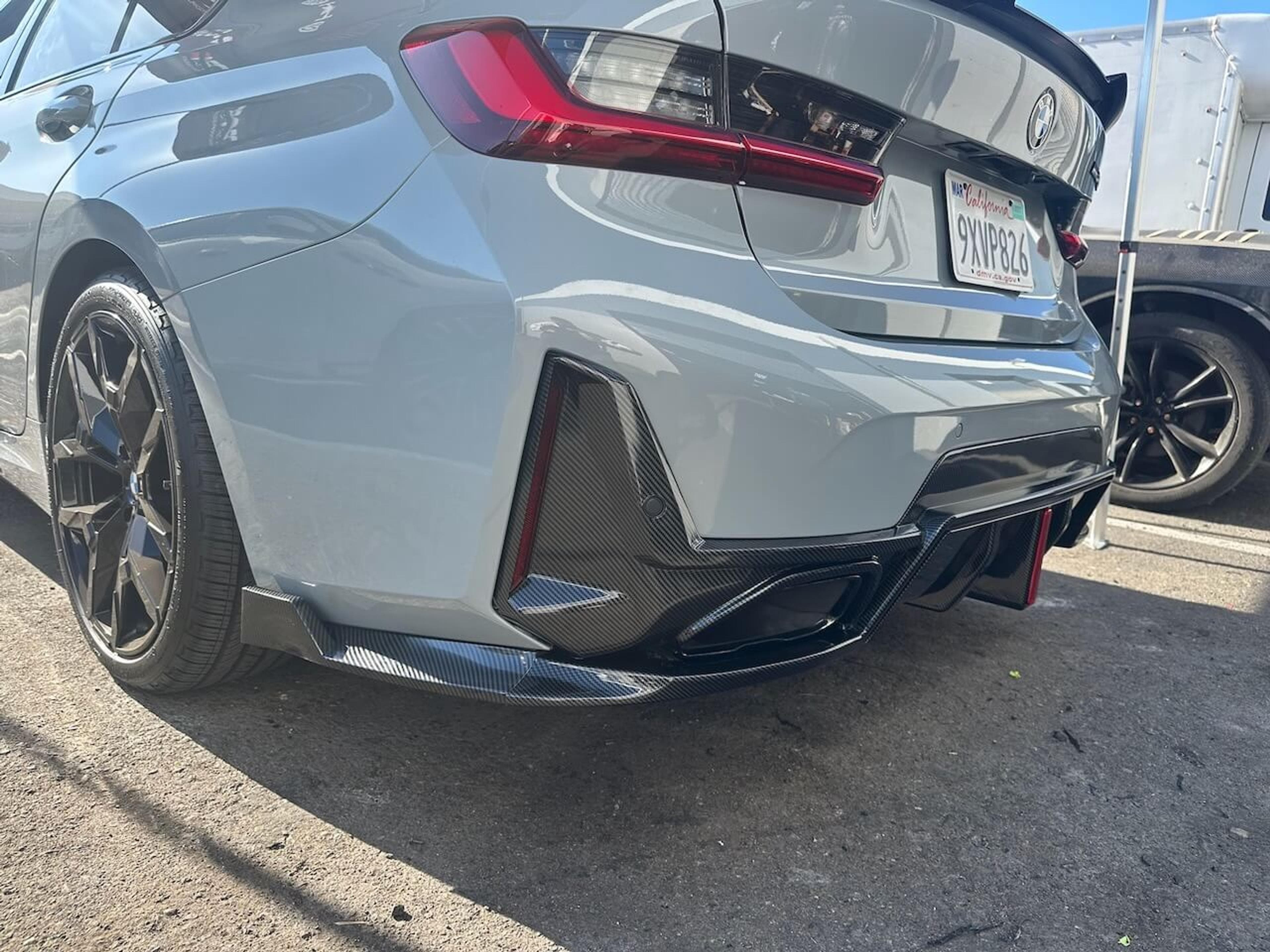 Rear three-quarter view of a gray BMW M340i with an installed carbon fiber rear diffuser